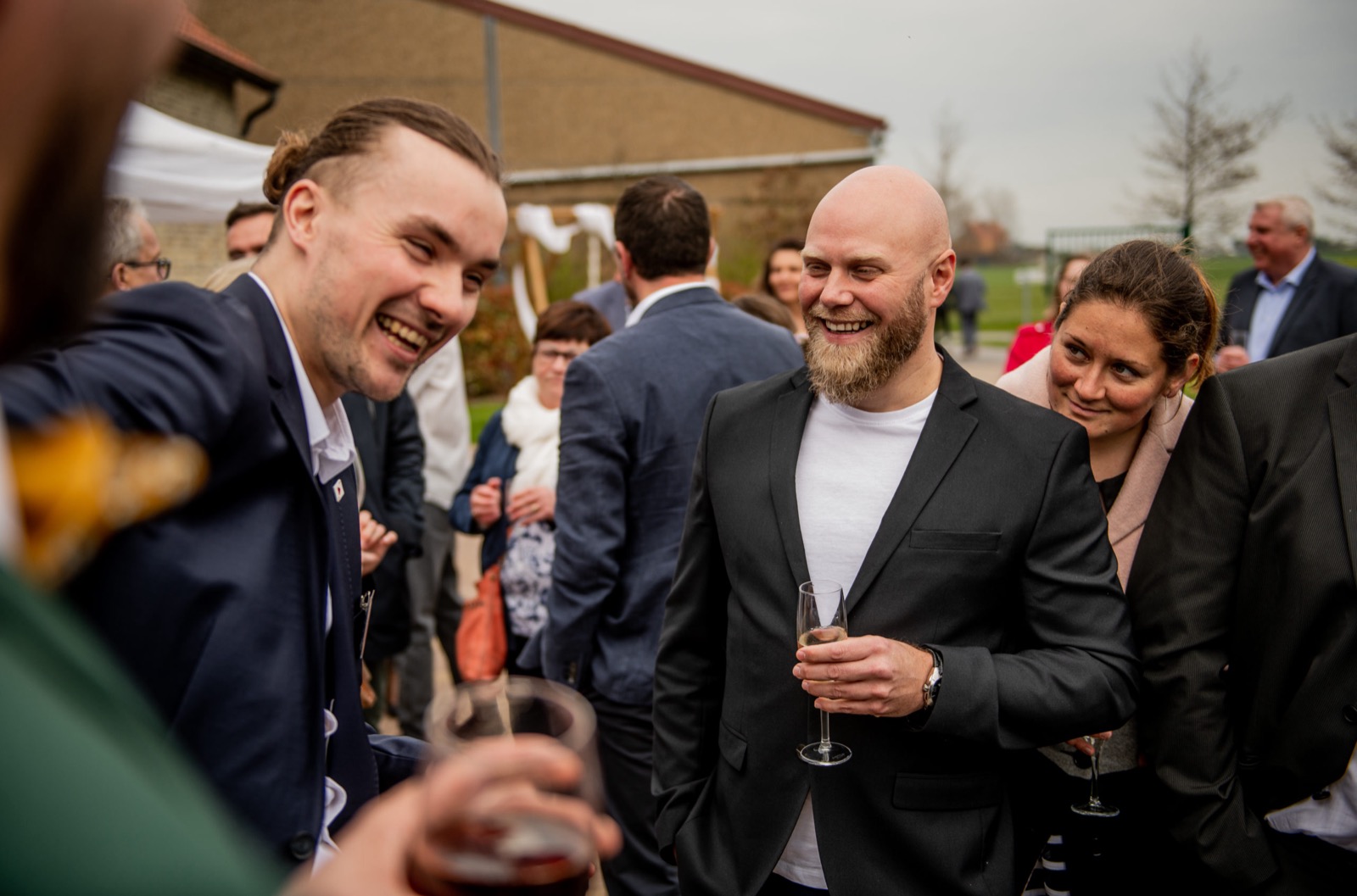 Invités d'un cocktail riant pendant un tour de Louis Magie