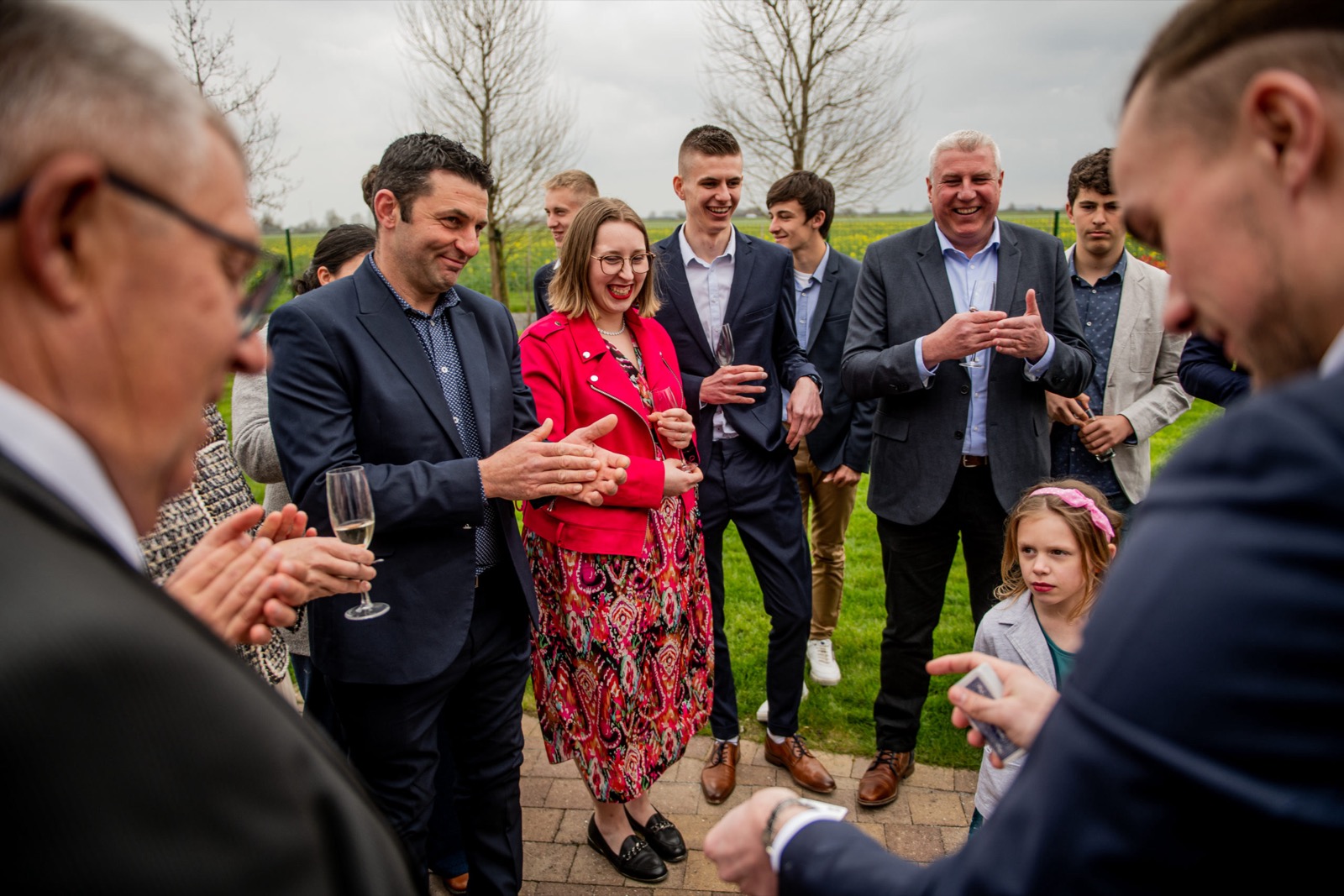 Louis Magie en close-up au vin d'honneur d'un mariage, les invités rient et applaudissent