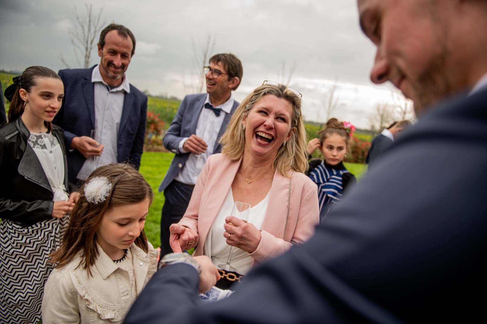 Invitée riant aux éclats pendant un tour de Louis Magie lors d'un mariage